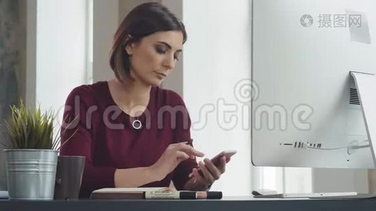 现代女性看着智能手机，在笔记本上做笔记视频