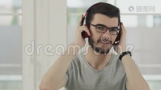 戴眼镜的人戴着耳机听音乐视频