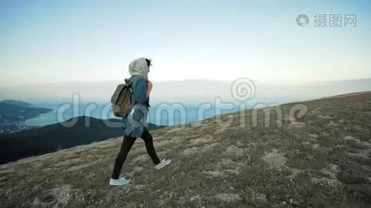 女徒步旅行者穿着背包在山上行走视频