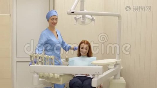 牙医在诊所里和一个女病人说话。视频