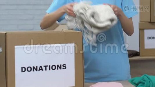 女志愿者把衣服放进捐款箱，慈善组织视频