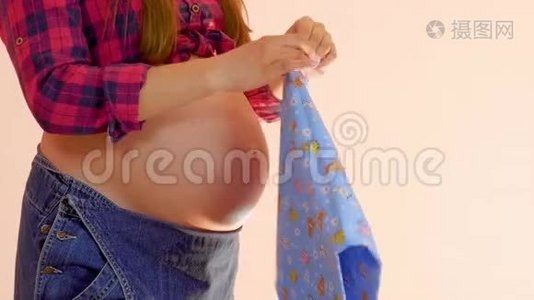 年轻孕妇为婴儿的出生准备襁褓。 怀孕和母性概念。 中型射击视频