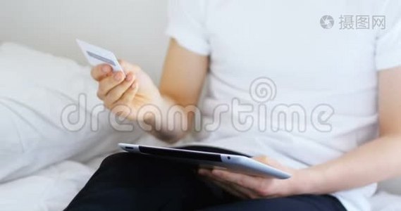 男子手持名片，在家使用数码平板电脑视频