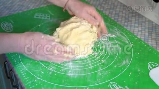 特写镜头，一位老年妇女的双手小心地将烘焙面团混合在厨房餐桌上视频
