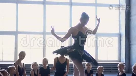 芭蕾舞学校的女舞蹈演员学会跳舞。 穿着黑色舞服训练的芭蕾舞女。 孩子们`芭蕾视频