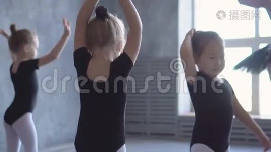 在芭蕾舞学校学跳舞的可爱女孩。穿着黑色舞衣训练的小芭蕾舞演员。儿童芭蕾舞视频