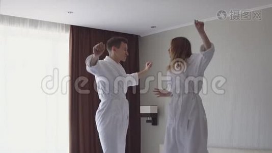 到达酒店后，年轻夫妇在床上跳跃和跳舞的慢动作视频视频
