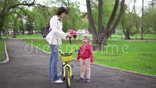 妈妈教小女儿骑自行车。视频