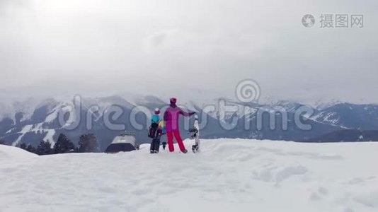 幸福的家庭在山上享受寒假。 家庭滑雪度假。 人们观察山景。视频