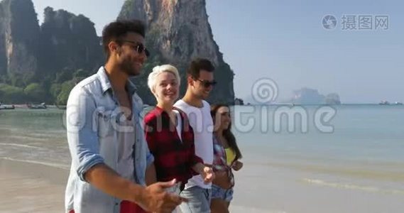 人们在沙滩上散步，谈两对情侣在度假时拥抱快乐的男女游客视频