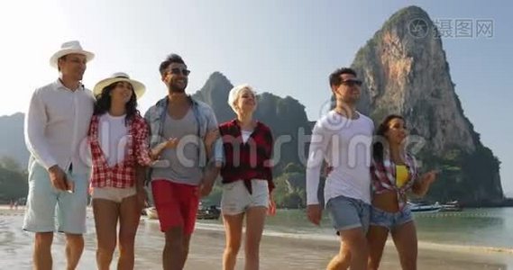人们在沙滩上集体散步谈三对夫妇在度假时拥抱快乐的男女游客视频