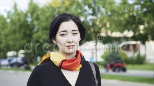 美丽的亚洲女人在街上看着摄像机视频