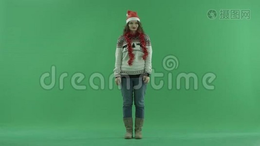 戴着圣诞帽的漂亮年轻女子想到了什么，背景上的色度键视频
