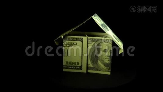 美元钞票的房子和核心围绕着黑色的背景。视频