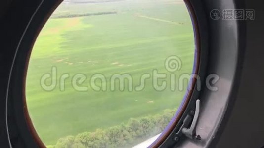 从直升机驾驶舱内看草地和田野。 在飞行过程中从直升机机舱观看。视频