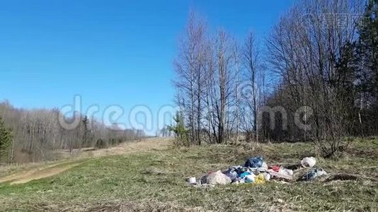 美丽的自然——田野，乡村道路和春天的树木.. 在大自然的背景下，一座小山的垃圾。视频