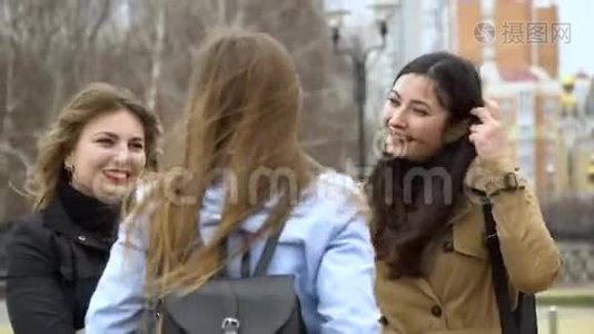 女孩的友谊。 三个年轻漂亮的女孩在街上聊天。 他们很开心。 女孩们很高兴见面。视频