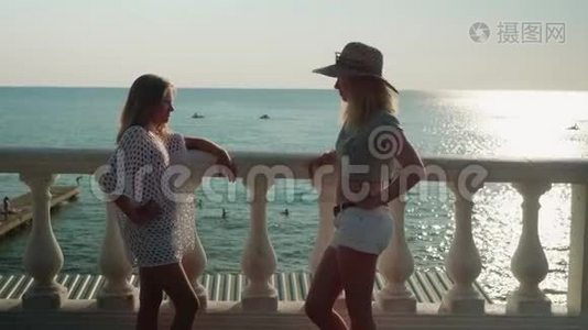 两个金发女人在大海和日落的背景下争吵视频