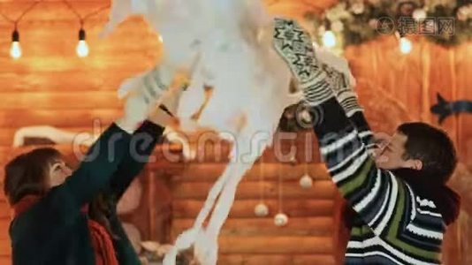 一男一女在童话般的房子背景下扔人造雪拥抱。圣诞节和新年主题。视频