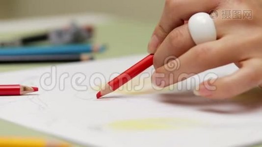 女孩用红铅笔左撇子画在纸上，用慢镜头细看视频
