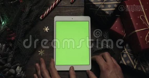 男性手滚动，用绿色屏幕放大白色平板电脑上的页面。 铬钥匙。 上景。 垂直视频