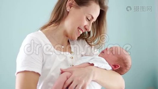 母亲怀里抱着一个新生婴儿.. 女人微笑，轻轻地抚摸他。 母亲的幸福。 母亲视频