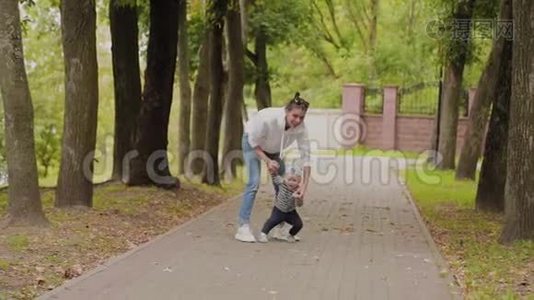 快乐的妈妈和她的儿子在公园里散步。视频