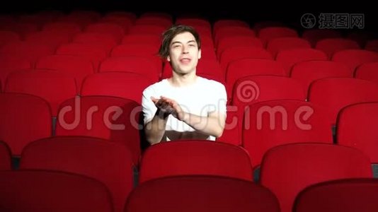 一个人独自坐在空荡荡的电影院或剧院里鼓掌视频