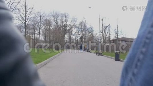 年轻漂亮的夫妇正在公园里散步。 牵着手。 他们`从摄像机里出来的。 慢动作。视频