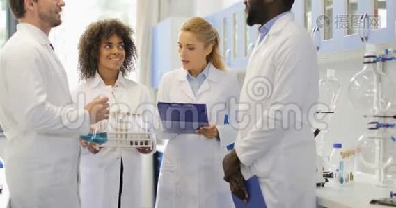 严肃的科学家女性与她的团队讨论化学物质，让研究人员在实验室工作视频