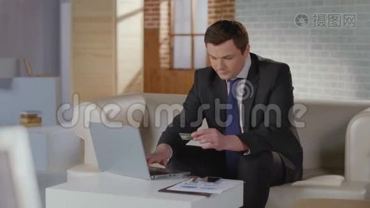 有钱人西装在笔记本电脑上插入信用卡号码视频