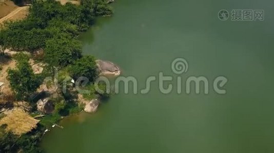 绿色的水和岸上的大石头，美丽的湖泊，从飞行无人机空中拍摄。 沿河而行的道路视频