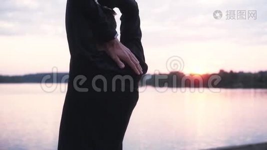 慢动作男子伸展手臂靠近日出湖。 后景男运动员热身美丽静景观..视频