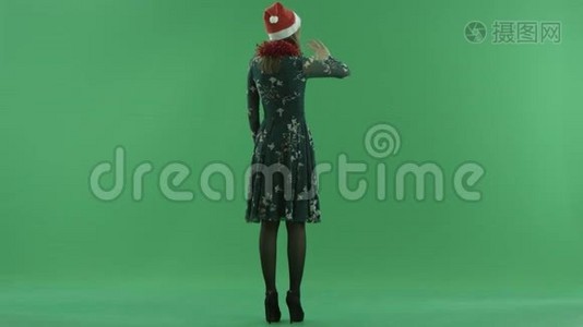 戴圣诞帽的年轻女子在虚拟环境中做手势，背景上的色度键视频