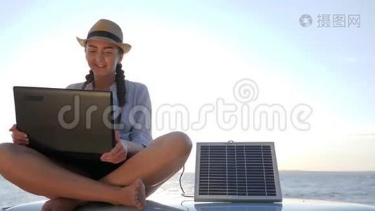 旅游业，女孩坐在车顶背光，笔记本电脑上说话，充电太阳能阵列，年轻女子坐在老式的视频