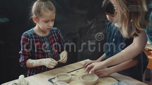与粘土一起工作的车间。 妈妈带着两个小女儿正忙着用粘土做模特。 家长和家长的共同创造力视频
