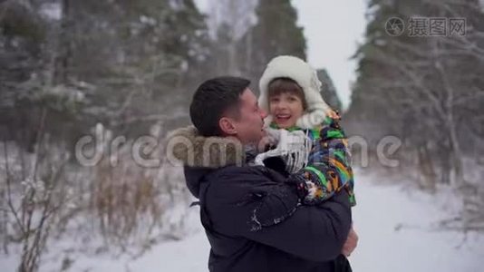 快乐父亲的肖像和一个非常可爱的快乐小男孩，他的儿子在一个雪冬公园。 微笑的男孩。 有吸引力的家庭视频