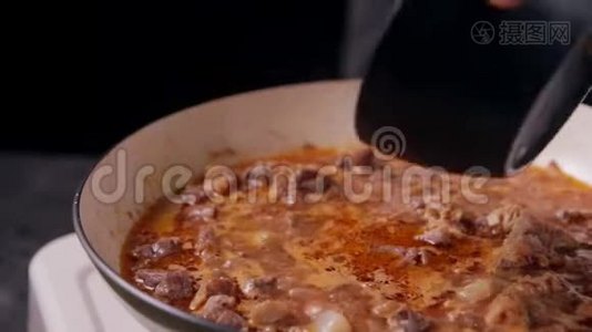 将切碎的土豆放入加牛肉的煎锅中。视频