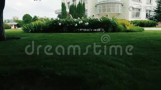 美丽的白色两层房子，风景如画的绿色花园视频