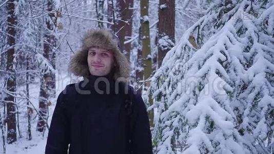 快乐的人走在白雪覆盖的寒冷的冬天森林里视频