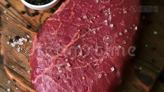 用盐和胡椒粉制成的生鲜牛排用于烤制木板视频