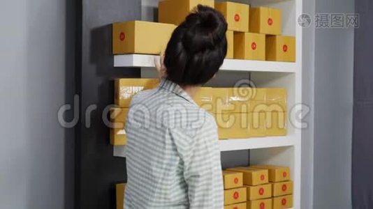 年轻女性企业家在自己的工作中在网上购物，数着包裹盒视频