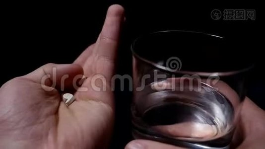 吃药。 手里拿着清水的药丸和杯子。 黑色背景视频