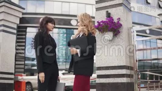 户外商业伙伴会议。 两个穿着紧身衣的女商人在谈论视频