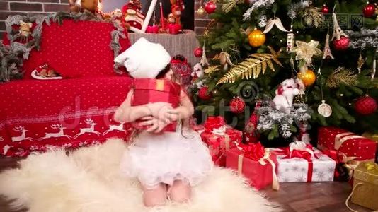 幸福快乐的小女孩收到了圣诞老人送给她的礼物，新年`有圣诞树的房间视频