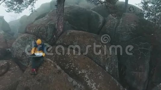 在冬天，坐在岩石顶部的人的视野被雾笼罩着视频