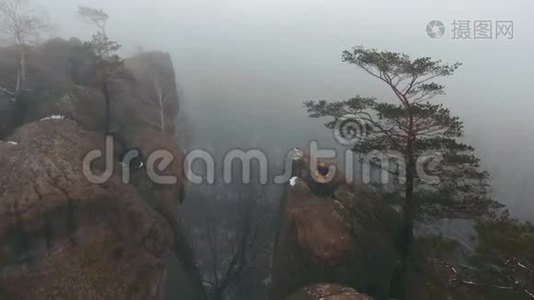 在冬天，坐在岩石顶部的人的视野被雾笼罩着视频