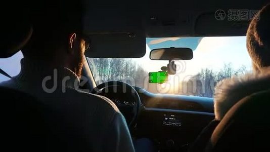 冬天开车的人。 智能手机有一个绿色屏幕连接在挡风玻璃上。视频