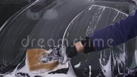 一个人洗了汽车玻璃。 手动洗车的概念视频
