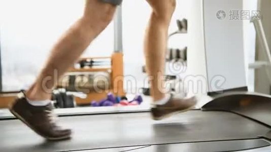 运动、健身、技术和人的概念-在健身房跑步机上接近男性腿视频